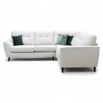 Front the sofa's corner section and armrest, highlighting the deep, supportive cushions and piped seams.