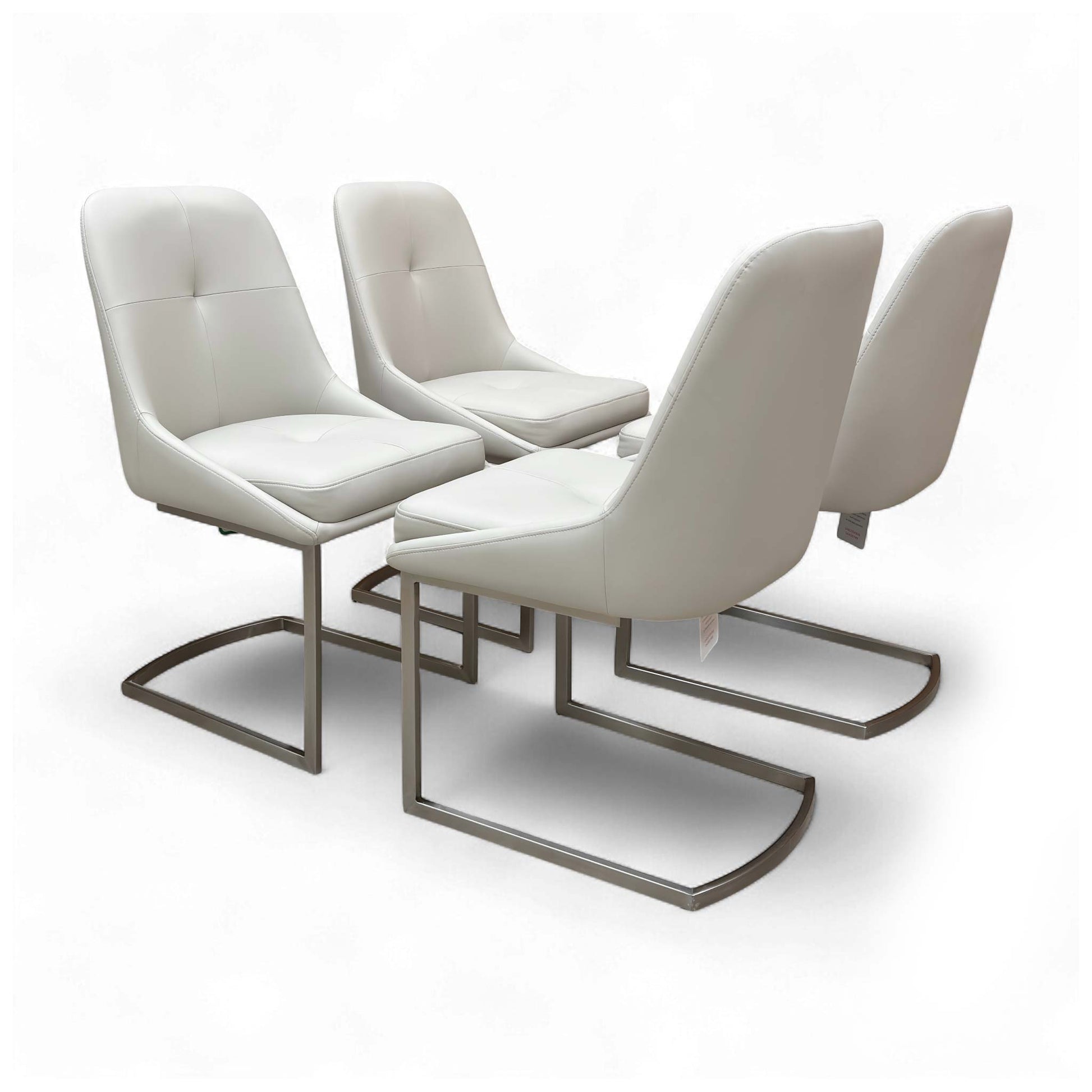 Angled view of the 'Avorio' Set of 4 Neutral Faux Leather Dining Chairs, showcasing their sleek design and cantilever chrome legs.