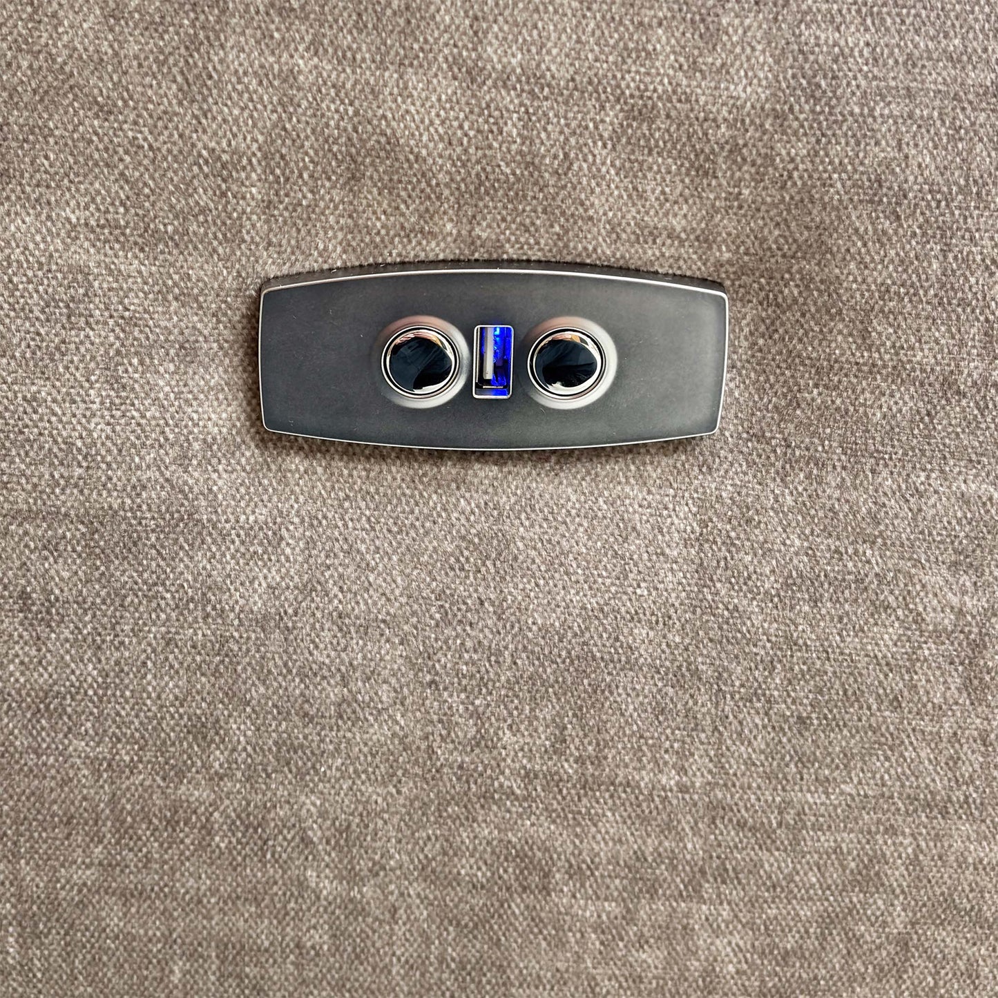 Close-up of the power recline control button located on the side of the armrest.