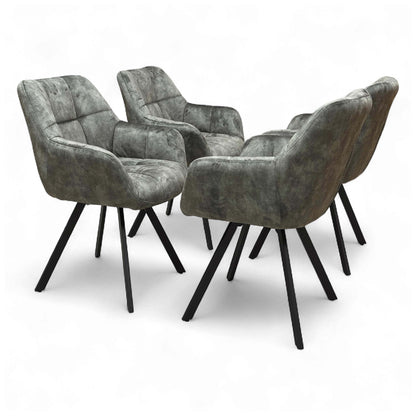 Angled view of the 'Jade' Olive Green Velvet Swivel Dining Chair, showcasing its upholstered seat and black metal legs.