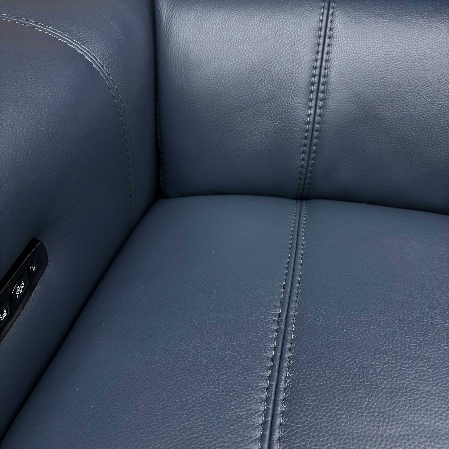 Detail shot of the armrest of the Ocean Blue Leather Sofa, highlighting the leather texture and the contrast stitching.