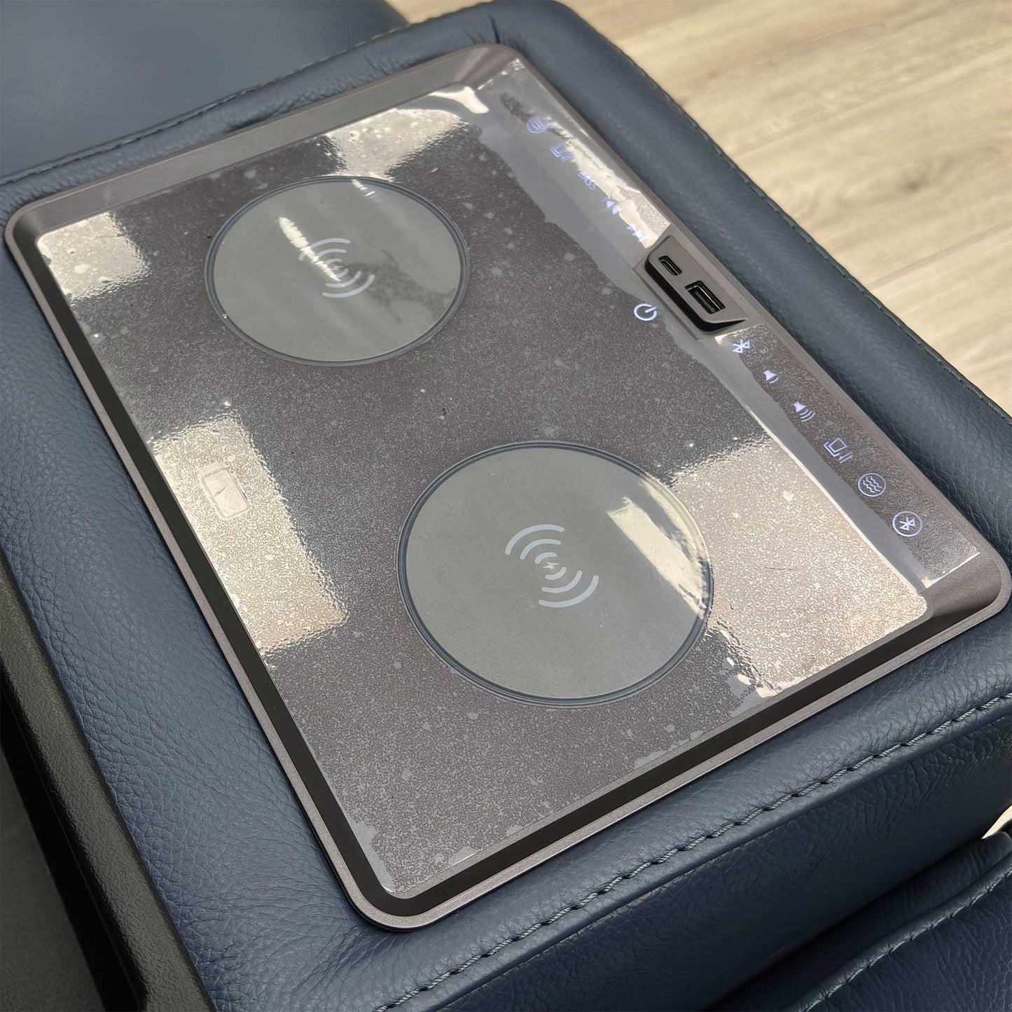 Close-up on the media console panel of the 'Homestage' sofa, showing the power buttons for recline/headrest and the USB/USB-C charging ports.