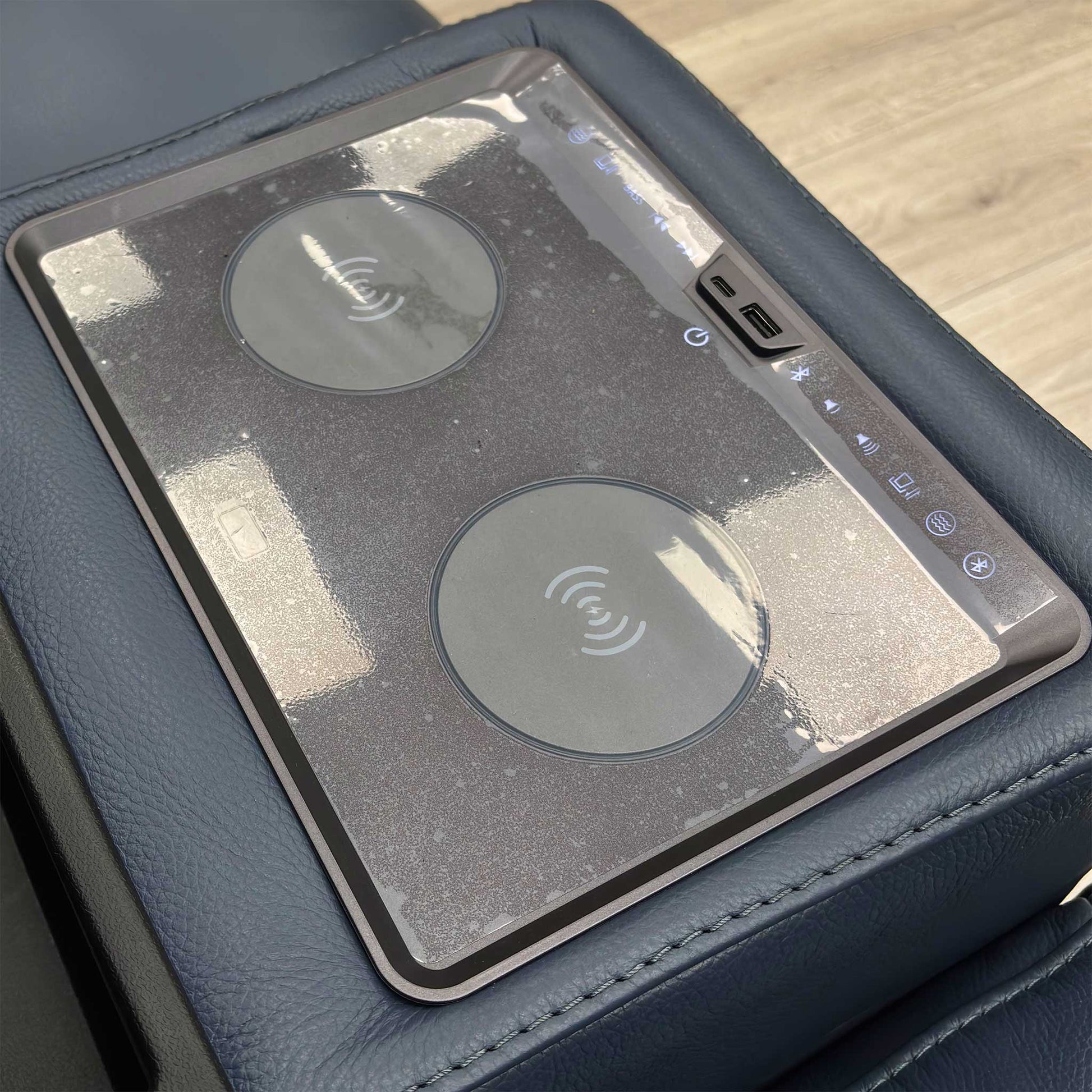 Close-up on the media console panel of the 'Homestage' sofa, showing the power buttons for recline/headrest and the USB/USB-C charging ports.