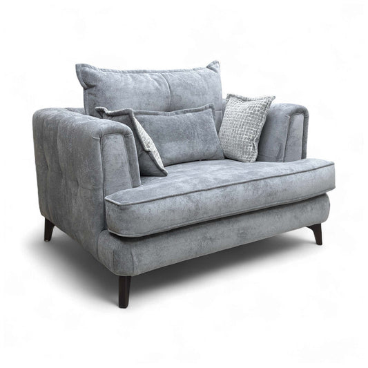 Angled front view of the 'Farrah' Classic Back Snuggler Chair in Riga Grey fabric with Zena Silver accent cushion.