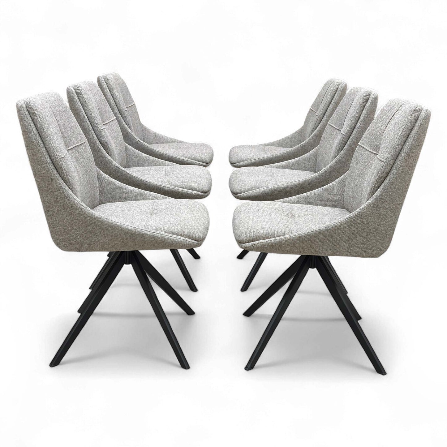 A modern dining setting featuring four of the six ‘Jasmine’ Latte Fabric Swivel Dining Chairs arranged around a dining table.