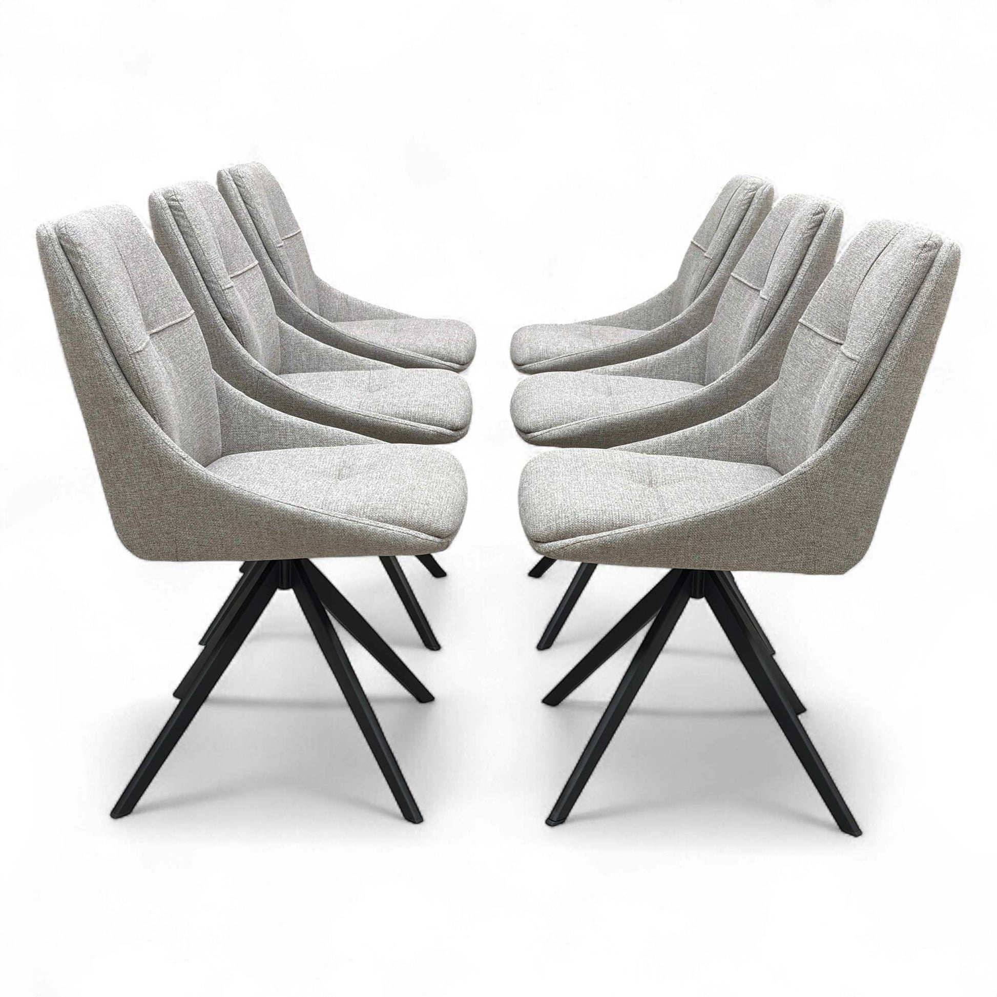 A modern dining setting featuring four of the six ‘Jasmine’ Latte Fabric Swivel Dining Chairs arranged around a dining table.