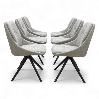 A modern dining setting featuring four of the six ‘Jasmine’ Latte Fabric Swivel Dining Chairs arranged around a dining table.