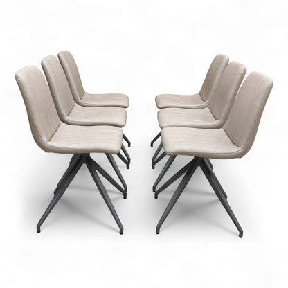 A contemporary dining setting showing four of the six ‘Isaac’ Taupe Faux Leather Dining Chairs arranged around a dining table.