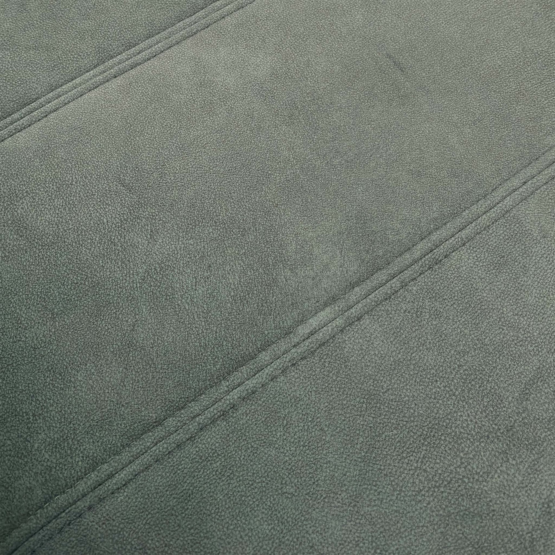 Close-up of the footstool's base and velvet fabric, highlighting the quality of the finish.