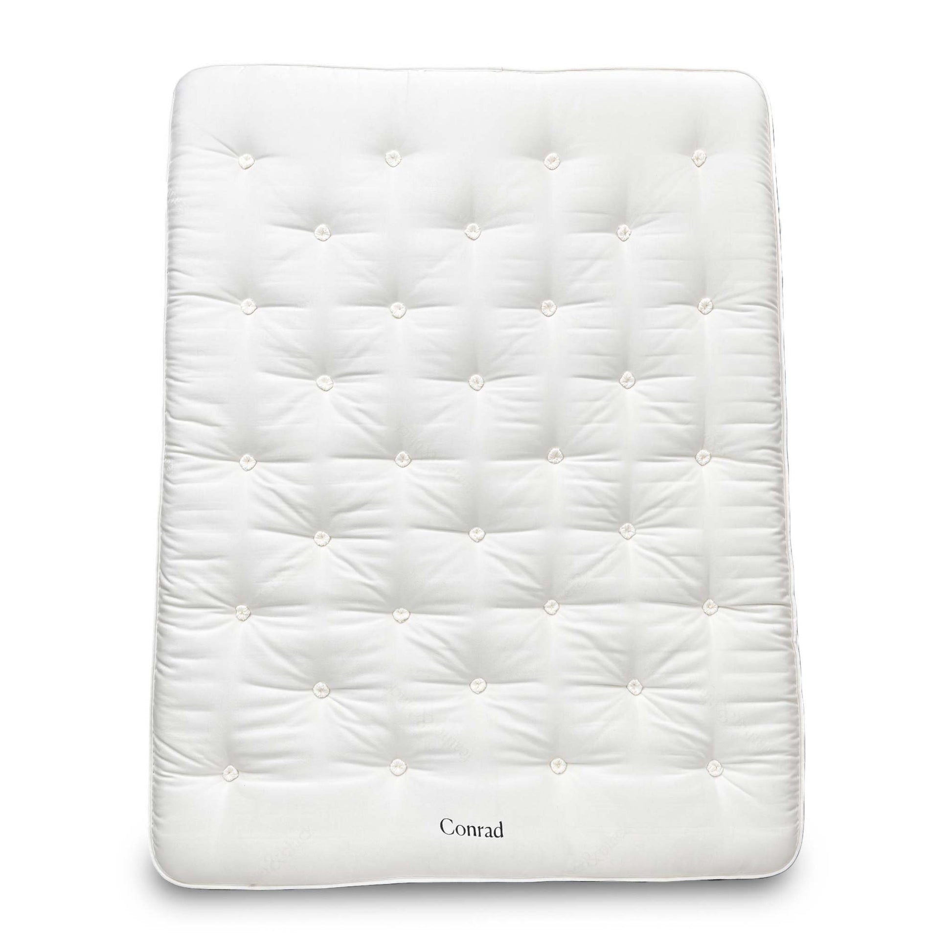 Full view of the King-size Harrison Spinks 'Conrad' 15750 Pocket Spring Mattress, featuring a luxurious white tufted top and firm vertical side stitching, displayed on a wooden base.