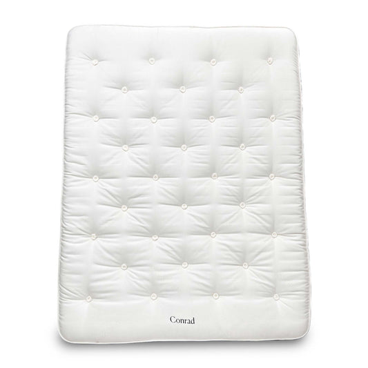 Full view of the King-size Harrison Spinks 'Conrad' 15750 Pocket Spring Mattress, featuring a luxurious white tufted top and firm vertical side stitching, displayed on a wooden base.