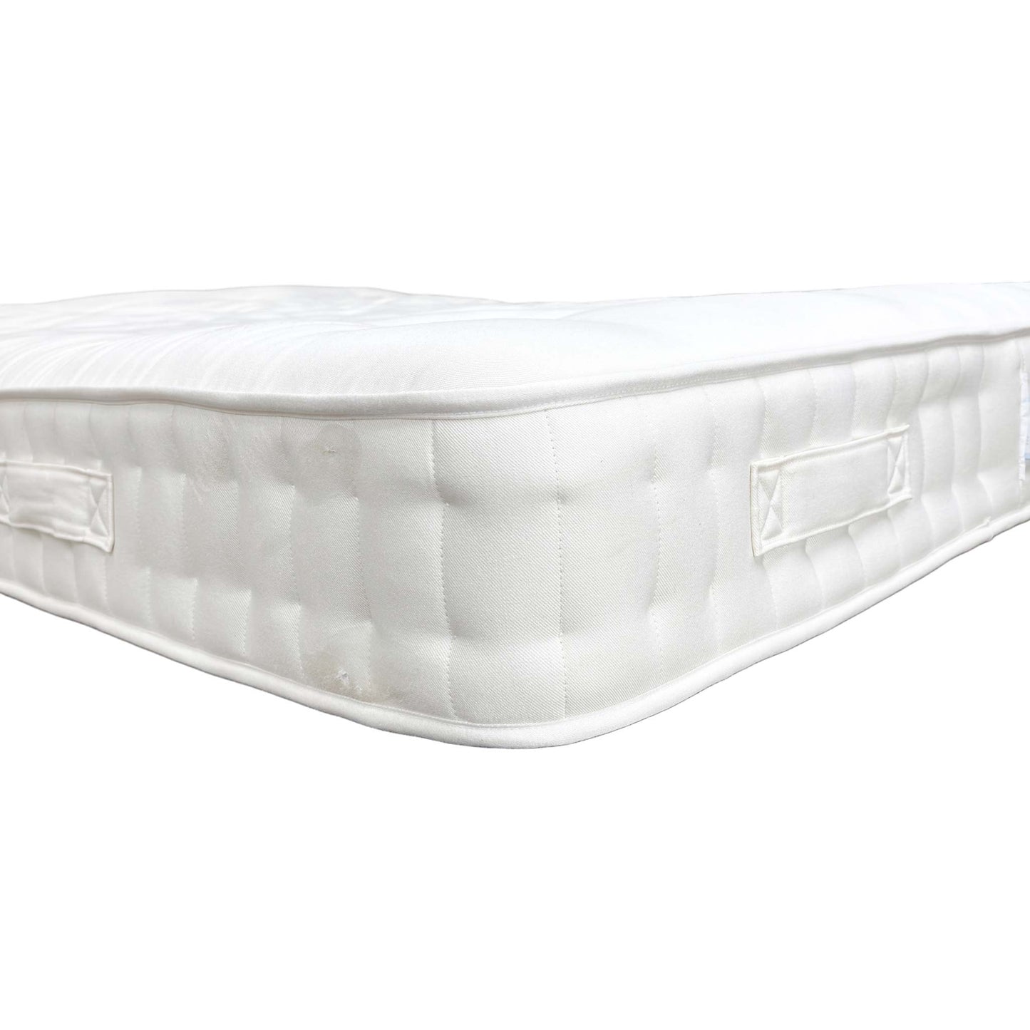 Close-up of the mattress corner/edge showing tufting.