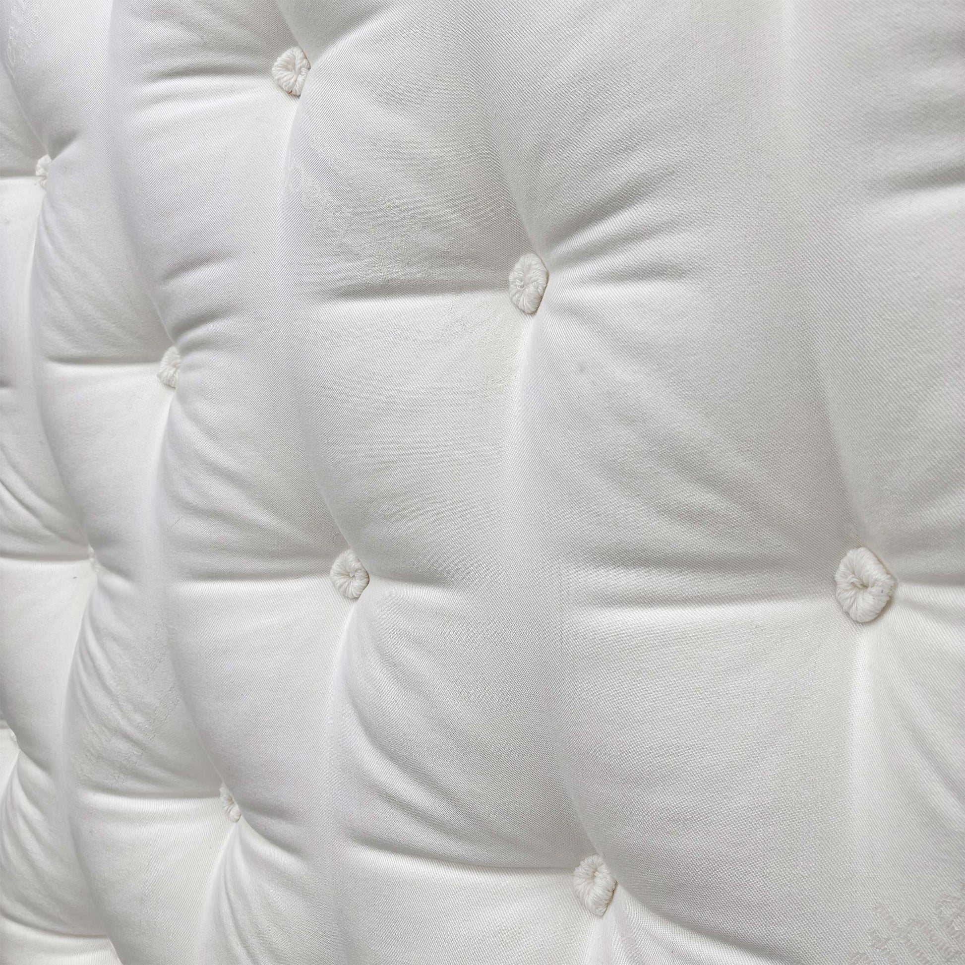 Detailed shot of the soft, breathable top fabric of the Harrison Spinks mattress, showing the tufting and luxurious texture.
