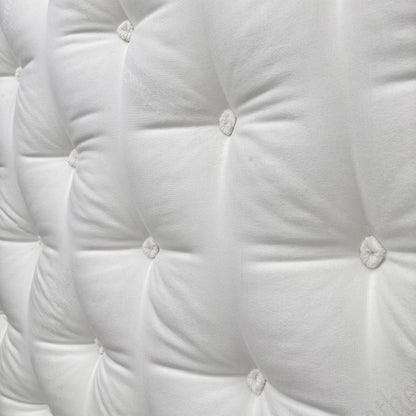 Detailed shot of the soft, breathable top fabric of the Harrison Spinks mattress, showing the tufting and luxurious texture.