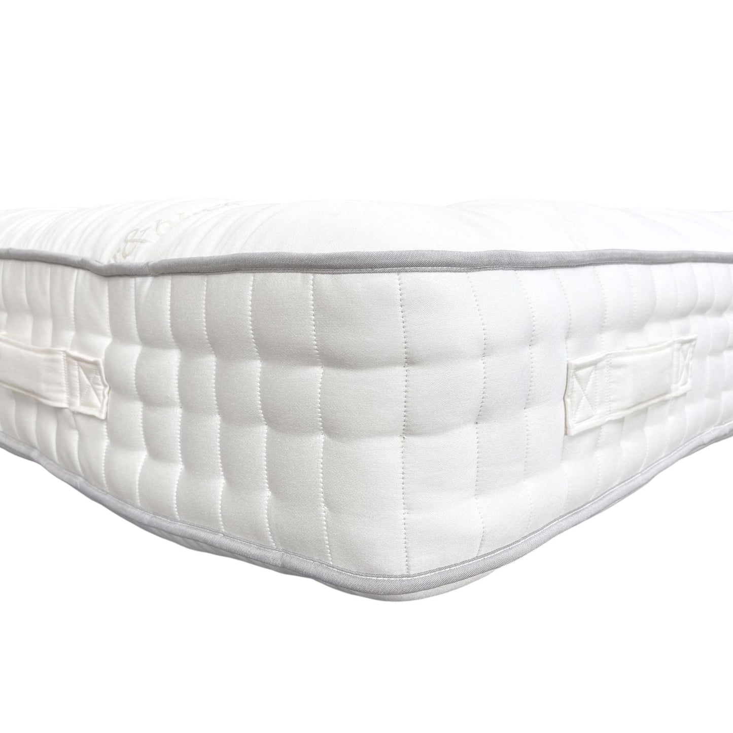 Detail of the mattress top, focusing on the breathable white fabric, natural fillings (Mohair), and secure hand-tufting.