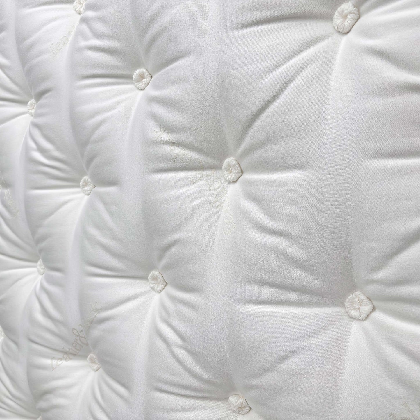 Close-up shot of the center of the mattress, indicating the Split Tension (Medium + Firm) design for personalized comfort on each half.