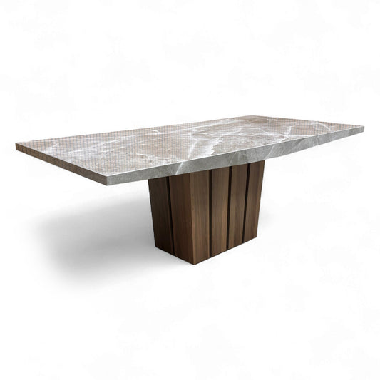 Angled view of the Empire dining table, highlighting the thickness of the solid marble top and its connection to the oak base.