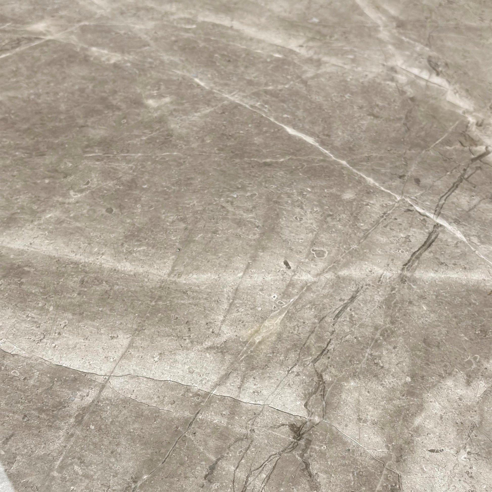 Close-up view of the natural, unique veining pattern on the solid marble rectangular tabletop of the Empire dining table.