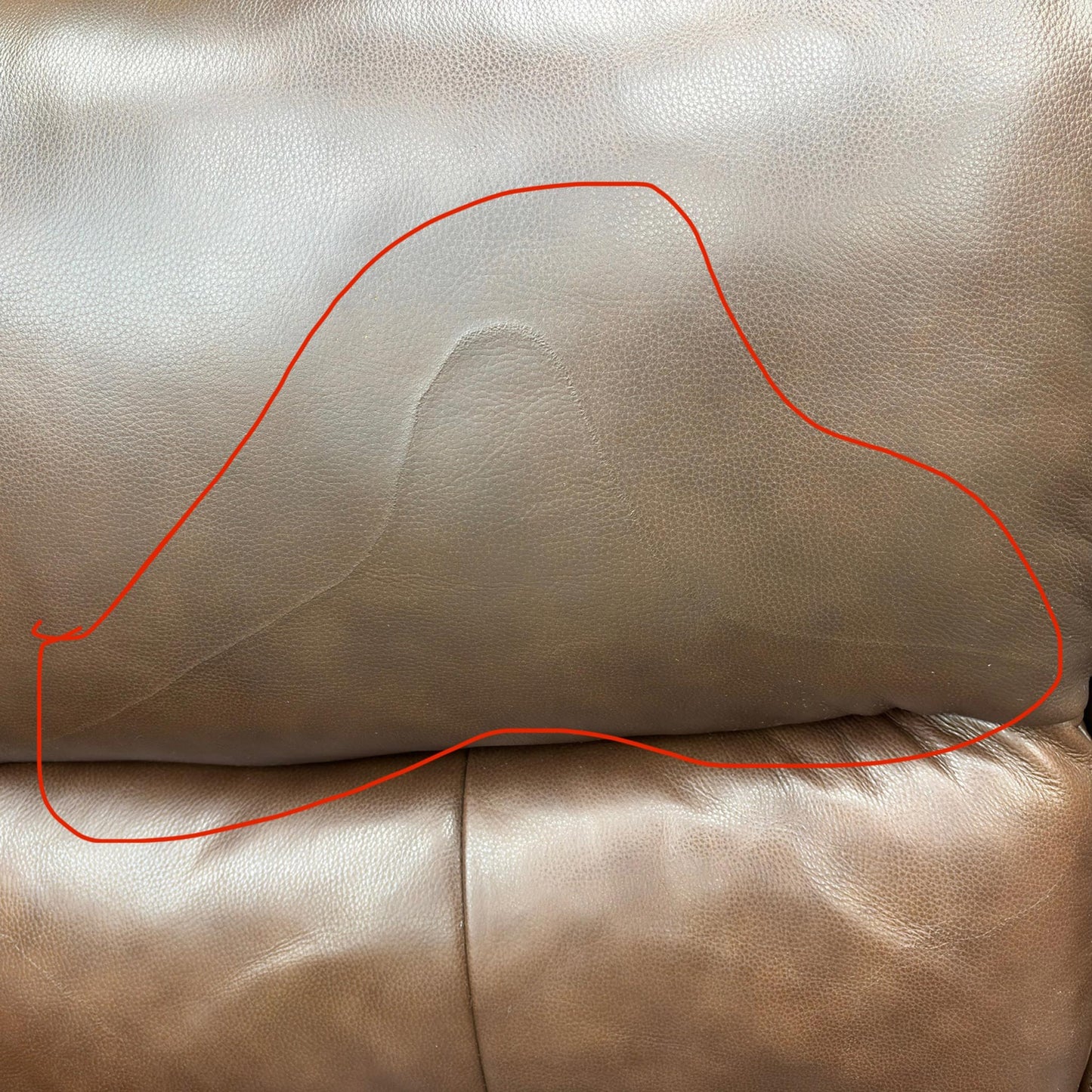 Close-up image showing specific damage or wear on the Butterscotch Brown Leather on the furniture set. (Condition note: Damage visible)
