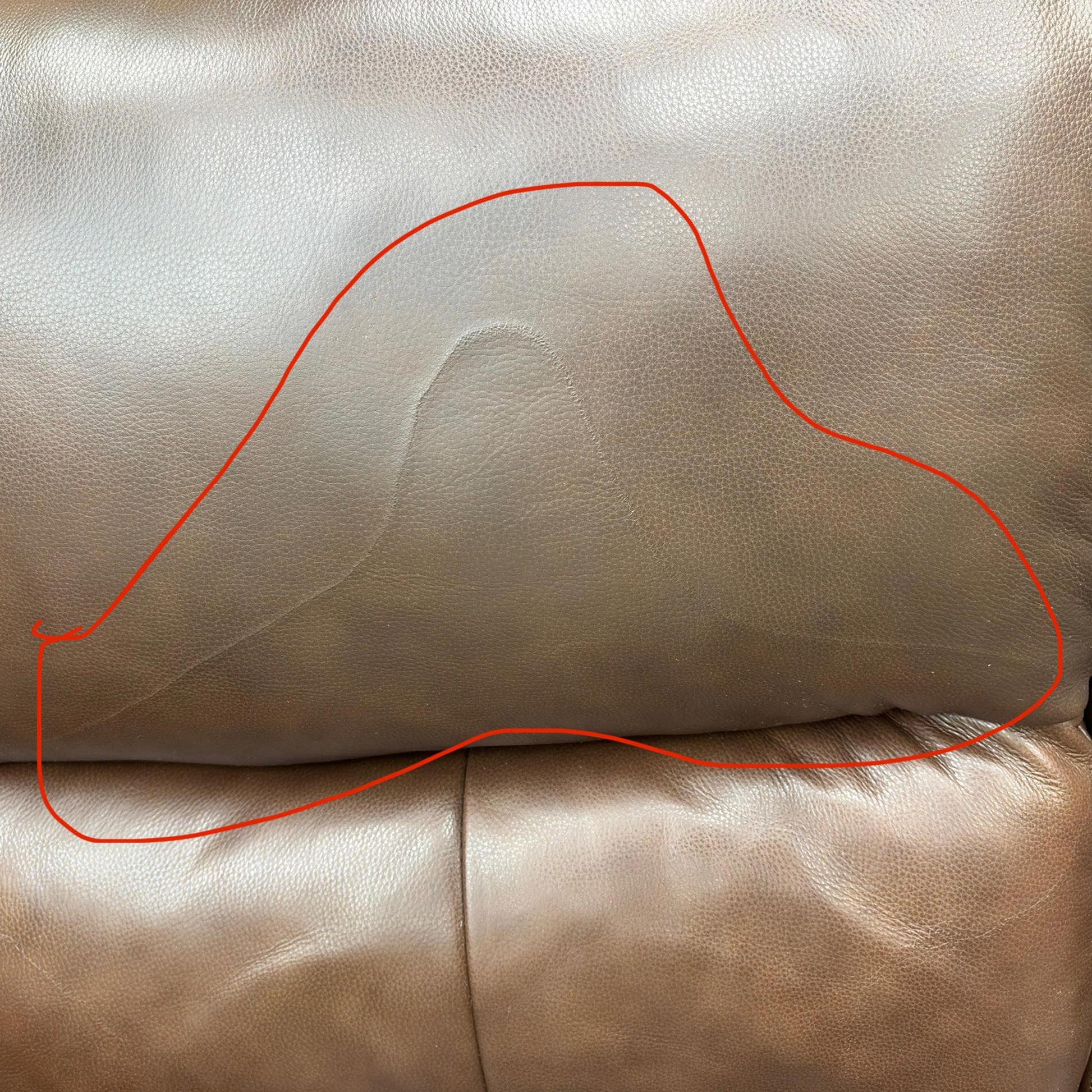 Close-up image showing specific damage or wear on the Butterscotch Brown Leather on the furniture set. (Condition note: Damage visible)