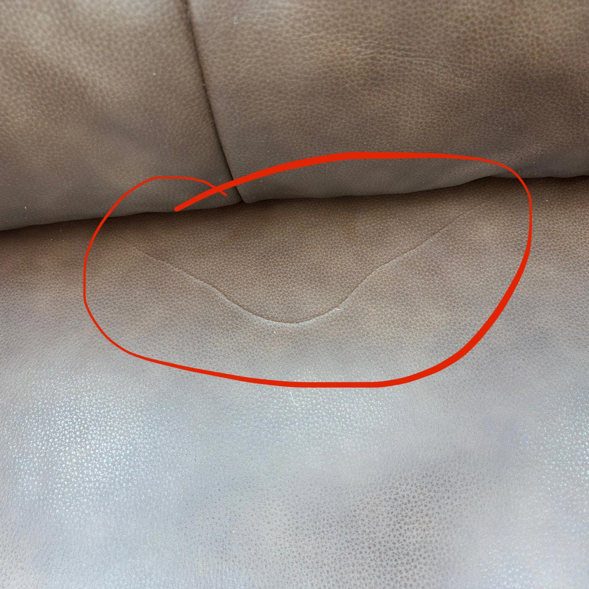 Close-up image showing specific damage or wear on the Butterscotch Brown Leather on the furniture set. (Condition note: Damage visible)