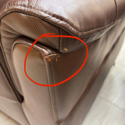 Brown leather chair with a red circle highlighting a small defect.