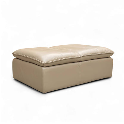 Full view of the World of Leather ‘Starlight Express’ Pebble Cream Leather Storage Footstool, highlighting its modern curves and versatile design as an extra seat.