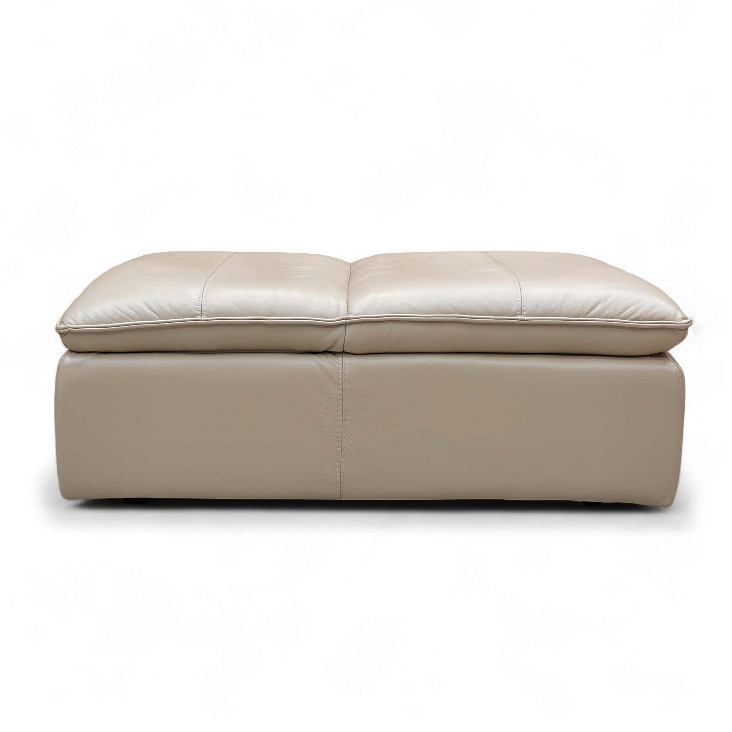 The Pebble Cream Storage Footstool opened, showcasing the large hidden internal storage space for keeping living room clutter organized.