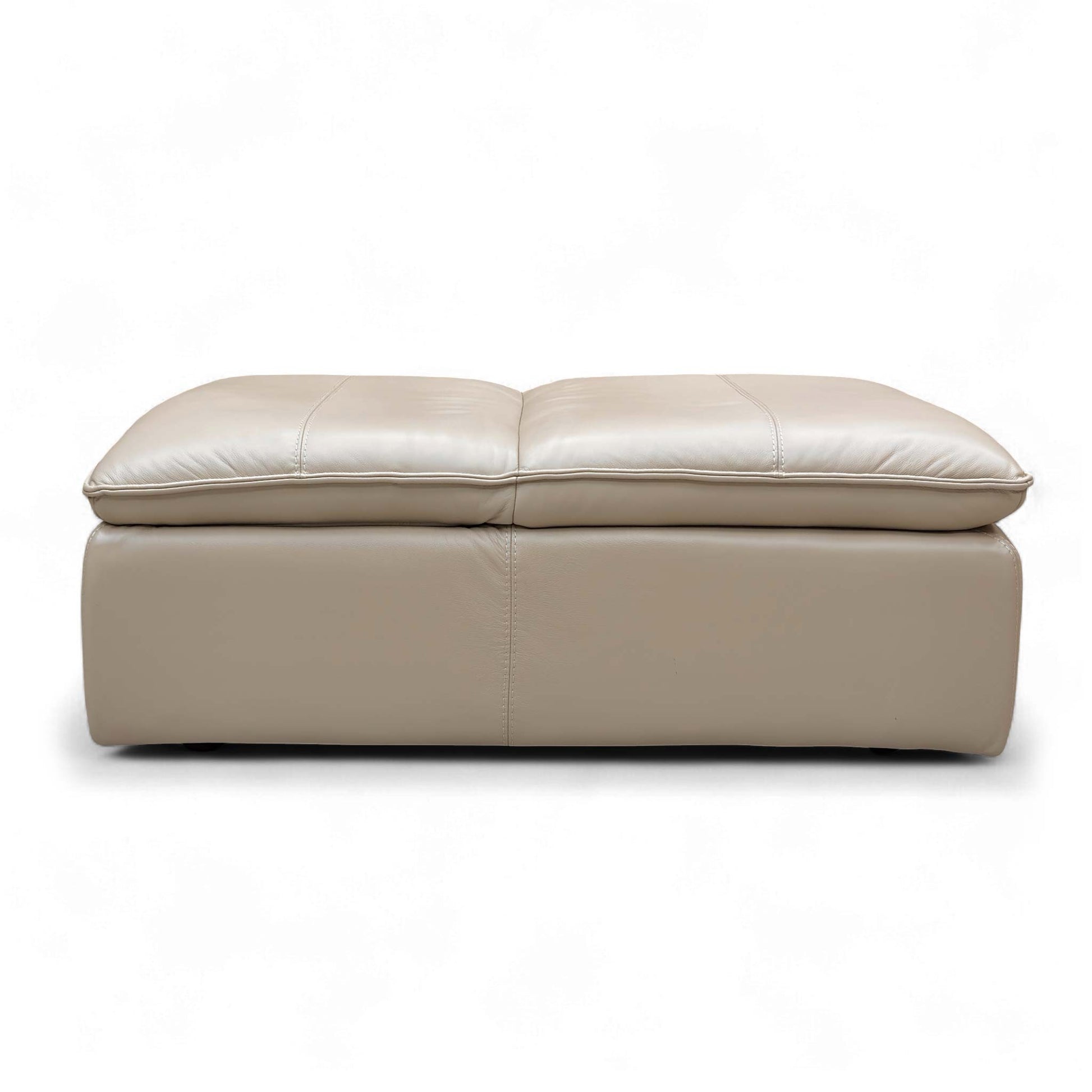 The Pebble Cream Storage Footstool opened, showcasing the large hidden internal storage space for keeping living room clutter organized.