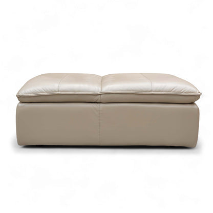 The Pebble Cream Storage Footstool opened, showcasing the large hidden internal storage space for keeping living room clutter organized.