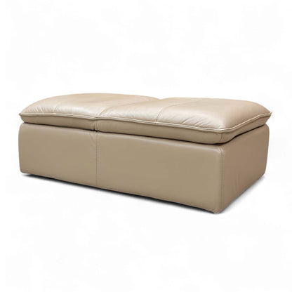 Angled view of the ‘Starlight Express’ Footstool, emphasizing the supple Pebble Cream leather and comfortable medium firmness cushioning.