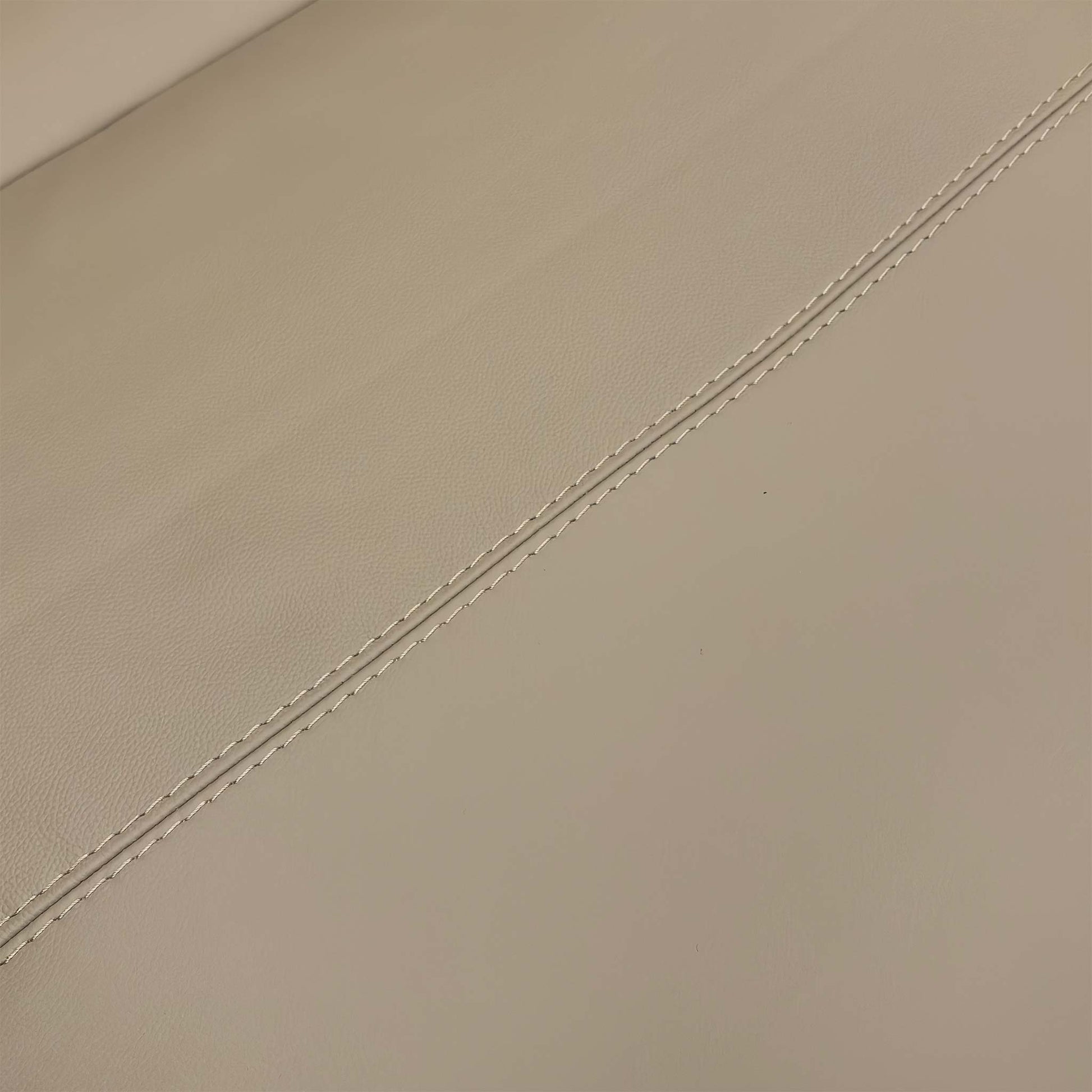 Detailed close-up of the texture and fine stitching on the Pebble Cream Leather upholstery.