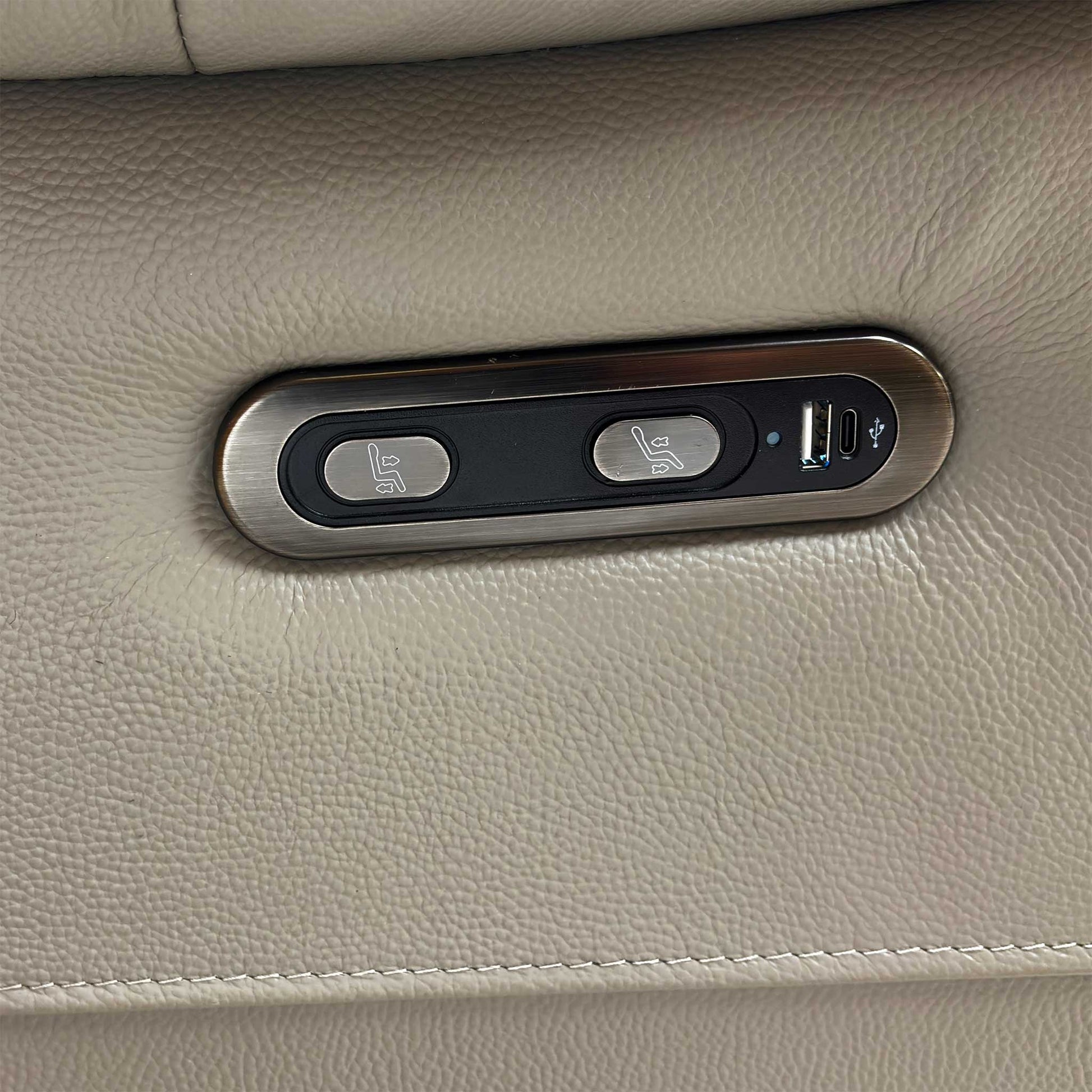 Close-up of the power control panel, which includes buttons for the power recliner, power headrest, and the built-in USB charging port.