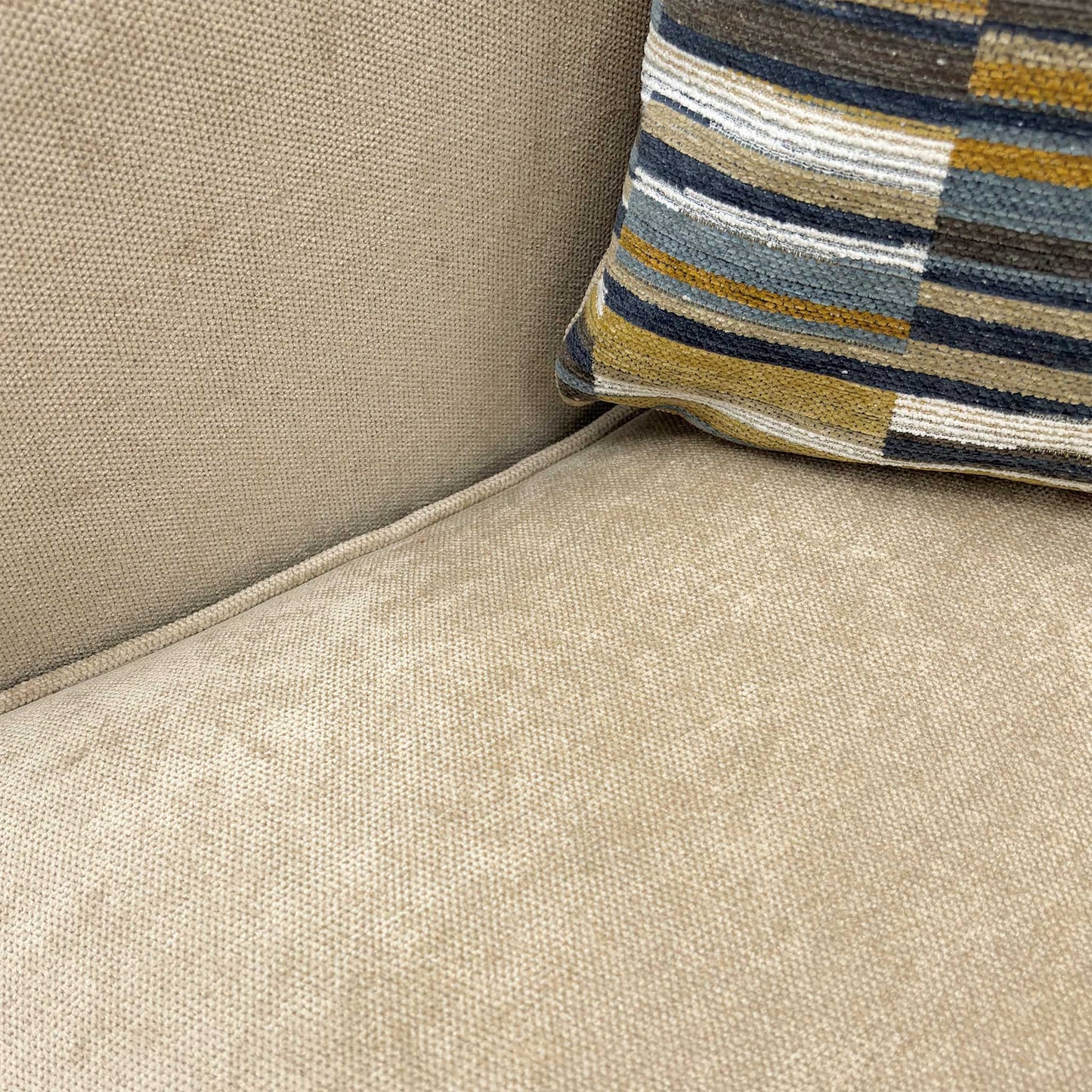 Close-up showing the fabric texture and dark wood feet.