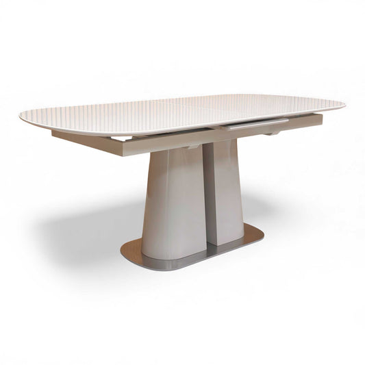 Angled view of the table in its closed, 180cm state, highlighting the high gloss finish.