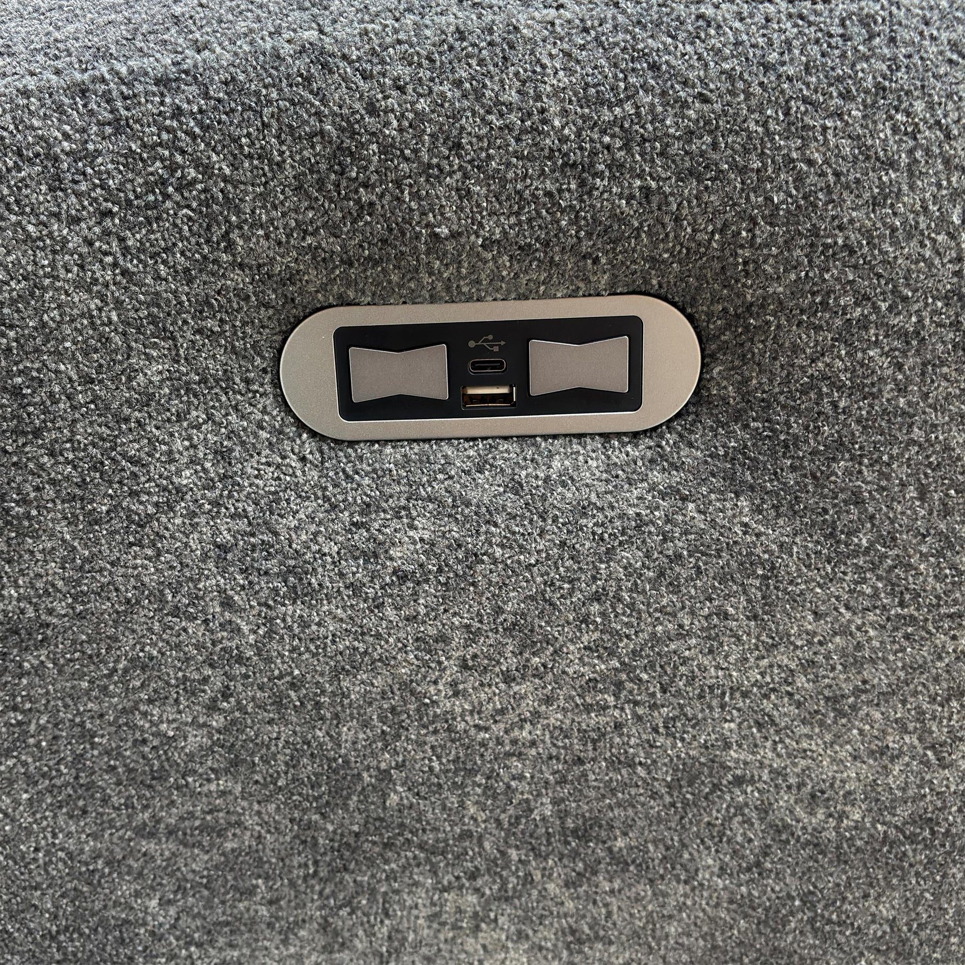 Close-up of the integrated power recliner button and USB charging port.