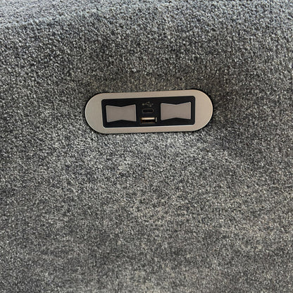 Close-up of the integrated power recliner button and USB charging port.