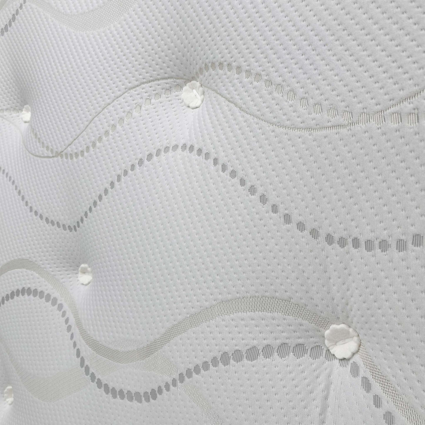 Close-up of the mattress corner, showing the material and hand-tufted design.
