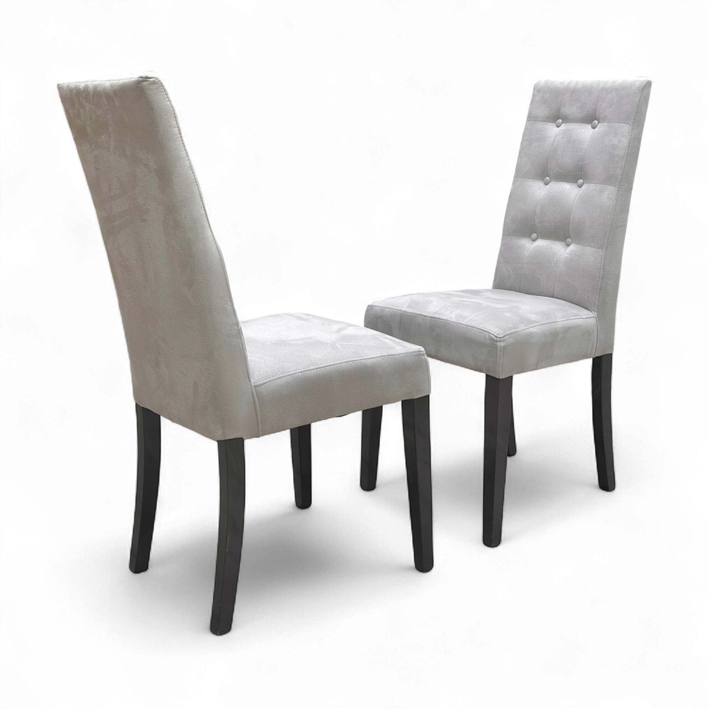 Angled view of the two Mia Silver Suede Dining Chairs, set ready for use, emphasizing their sophisticated style.