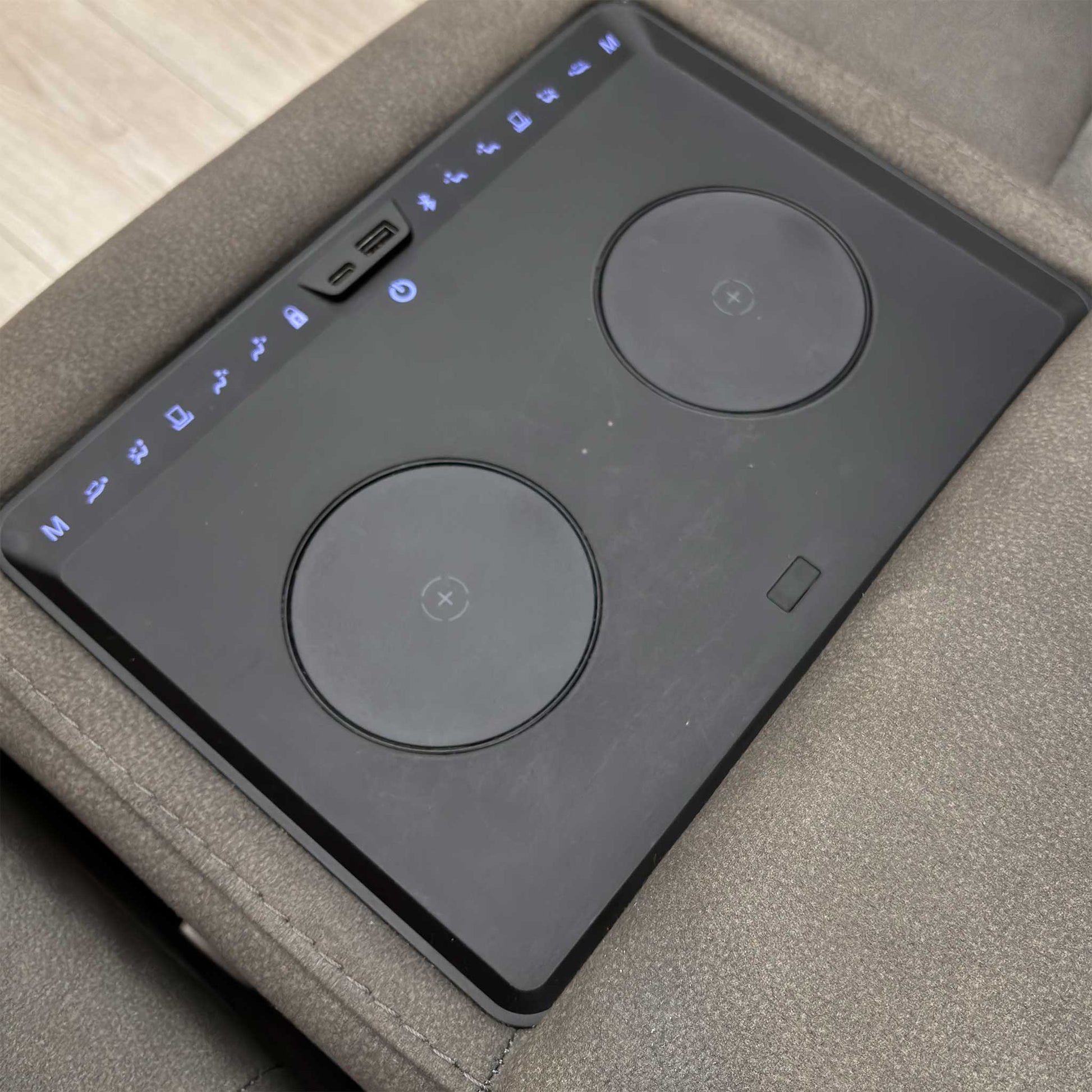 Detail of the power recliner controls and power headrest controls located on the side of the armrest.