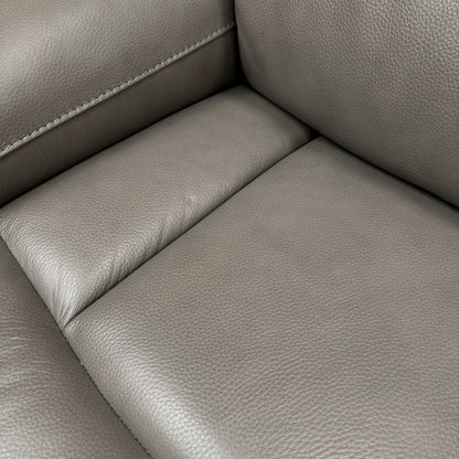 Close-up shot showing the base and low-profile feet of the Cinemax Grey Leather Sofa.