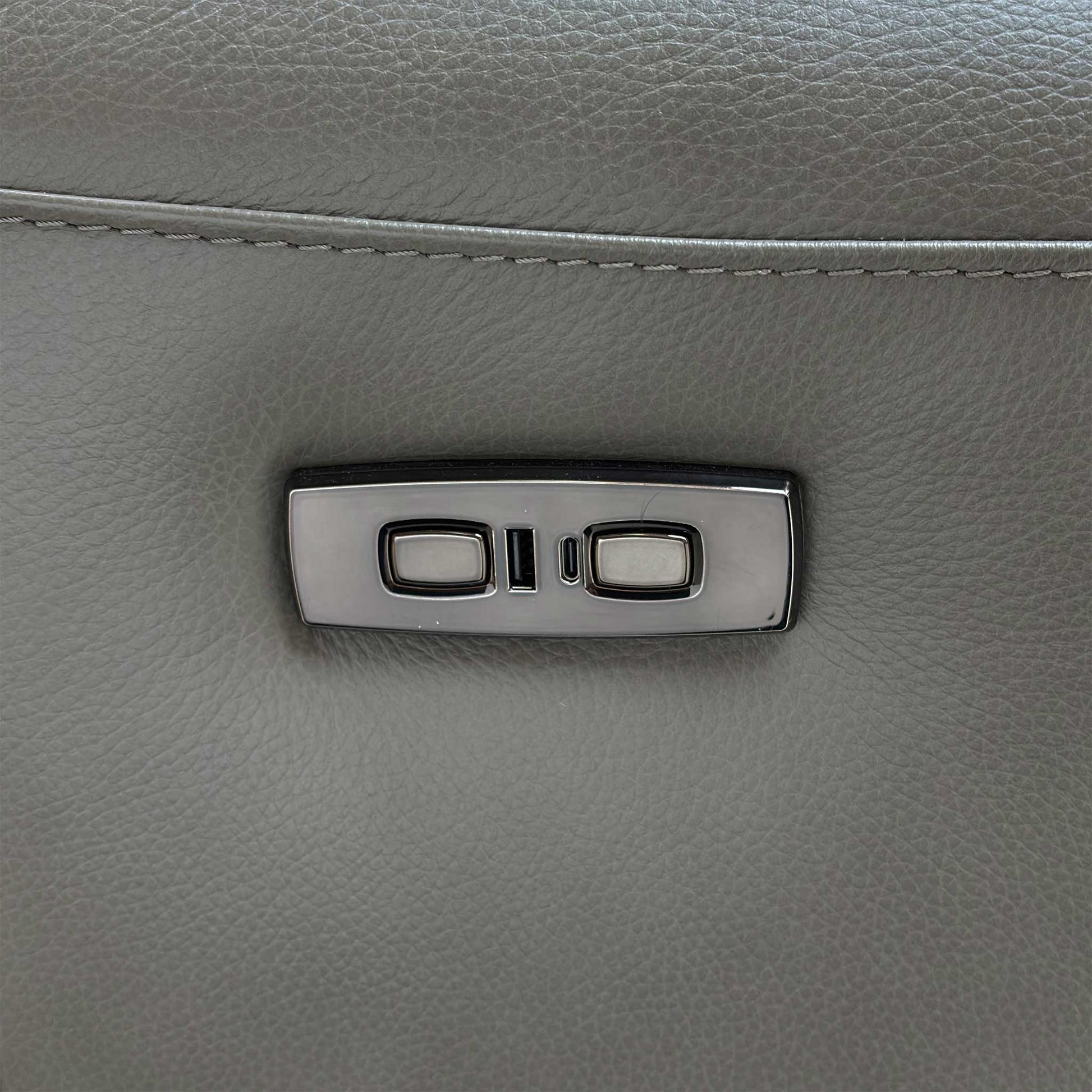 Close-up showing the integrated power recliner controls and USB charging port on the side of the armrest.