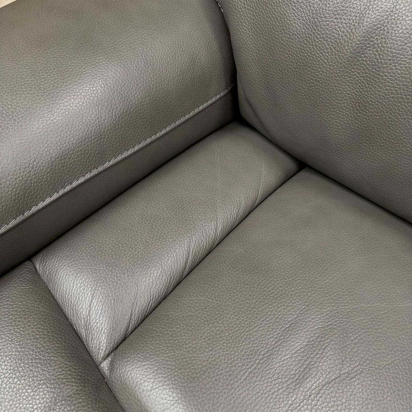 Close-up of the smooth grey LE 9308 leather upholstery and detailing on the fixed seat cushions.