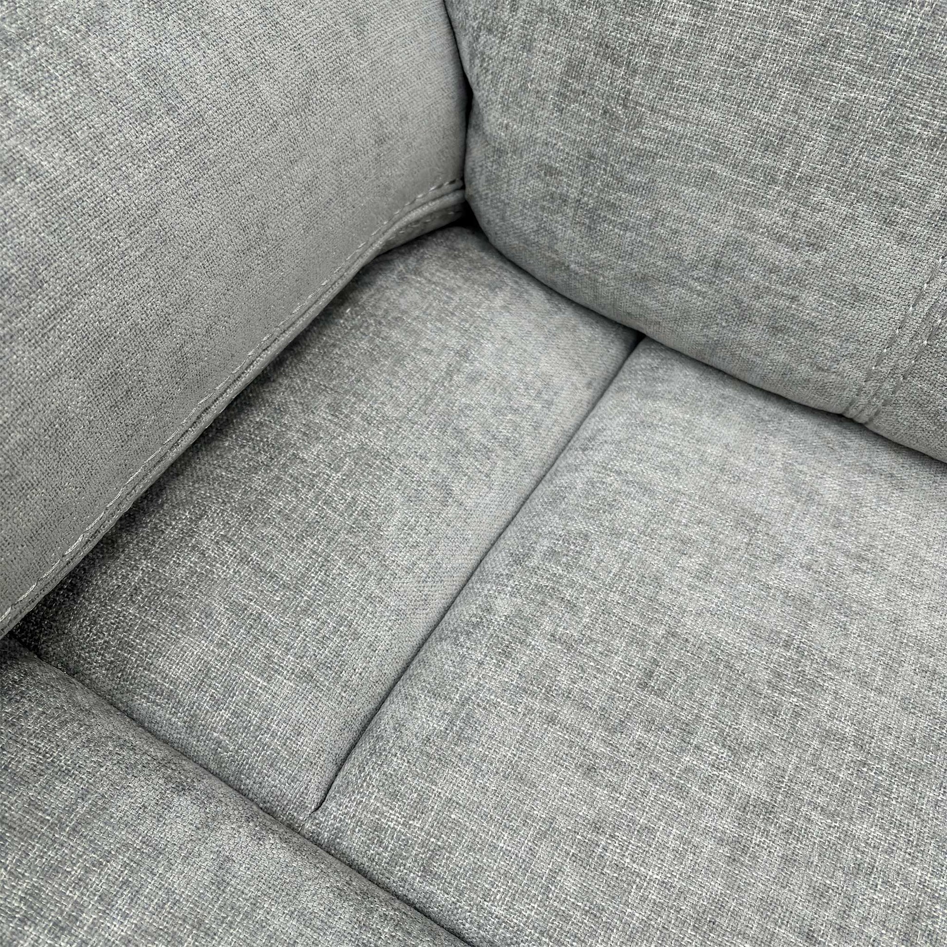 Detailed shot of the Light Grey Fabric upholstery and the plush, foam-filled seat cushion.