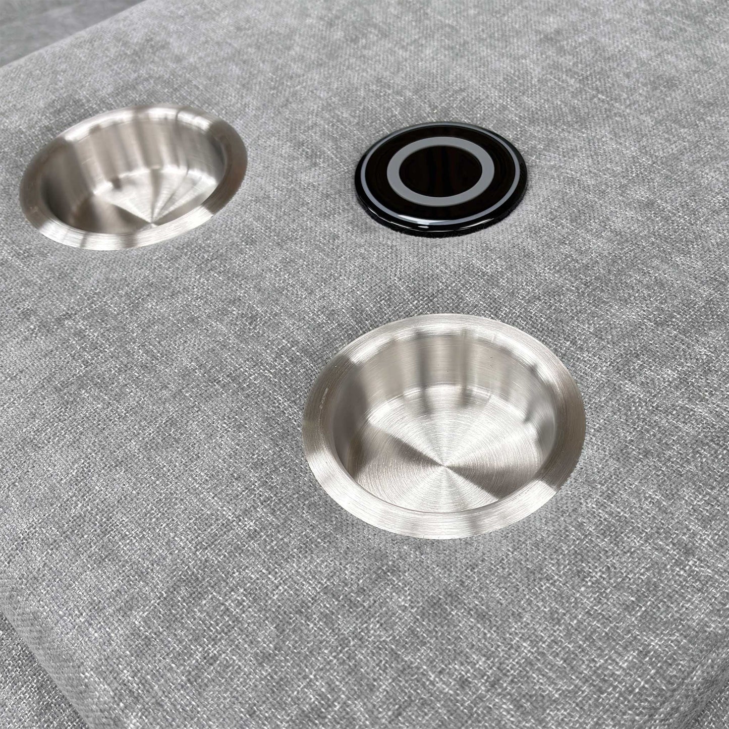 Close-up shot of the two circular cup holders within the dropped-down console of the middle seat.