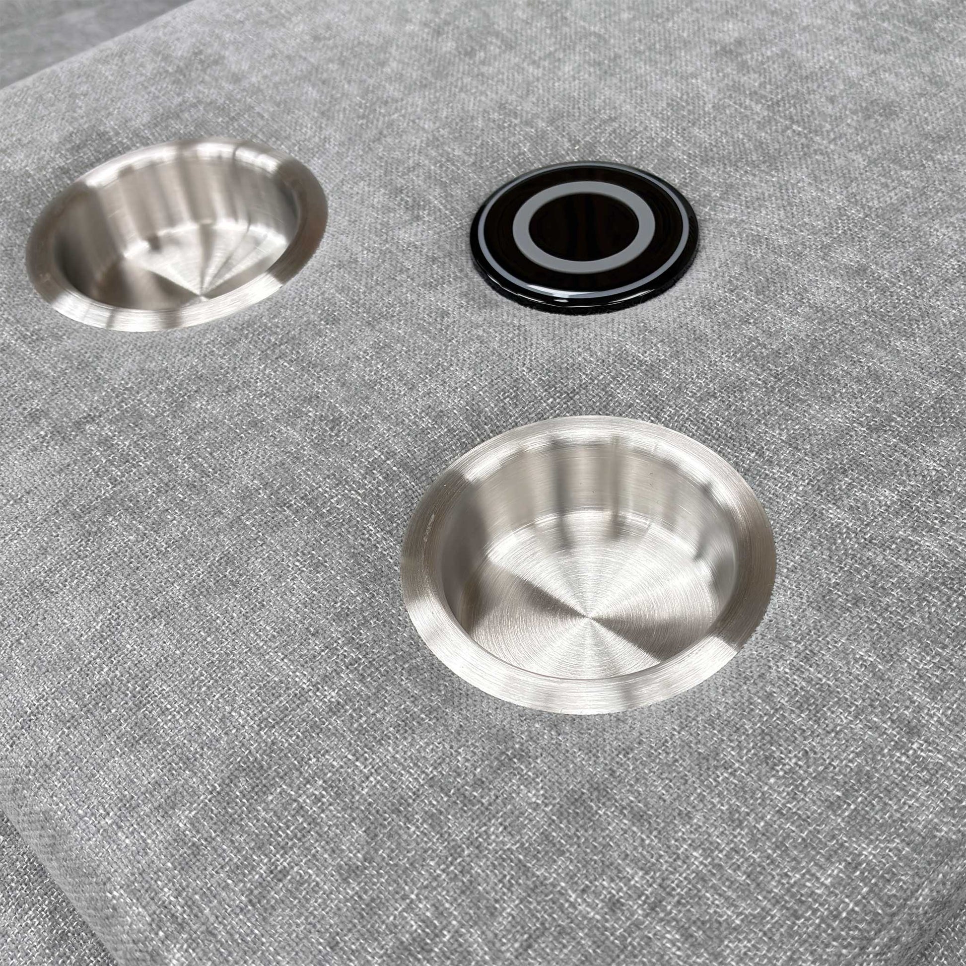 Close-up shot of the two circular cup holders within the dropped-down console of the middle seat.