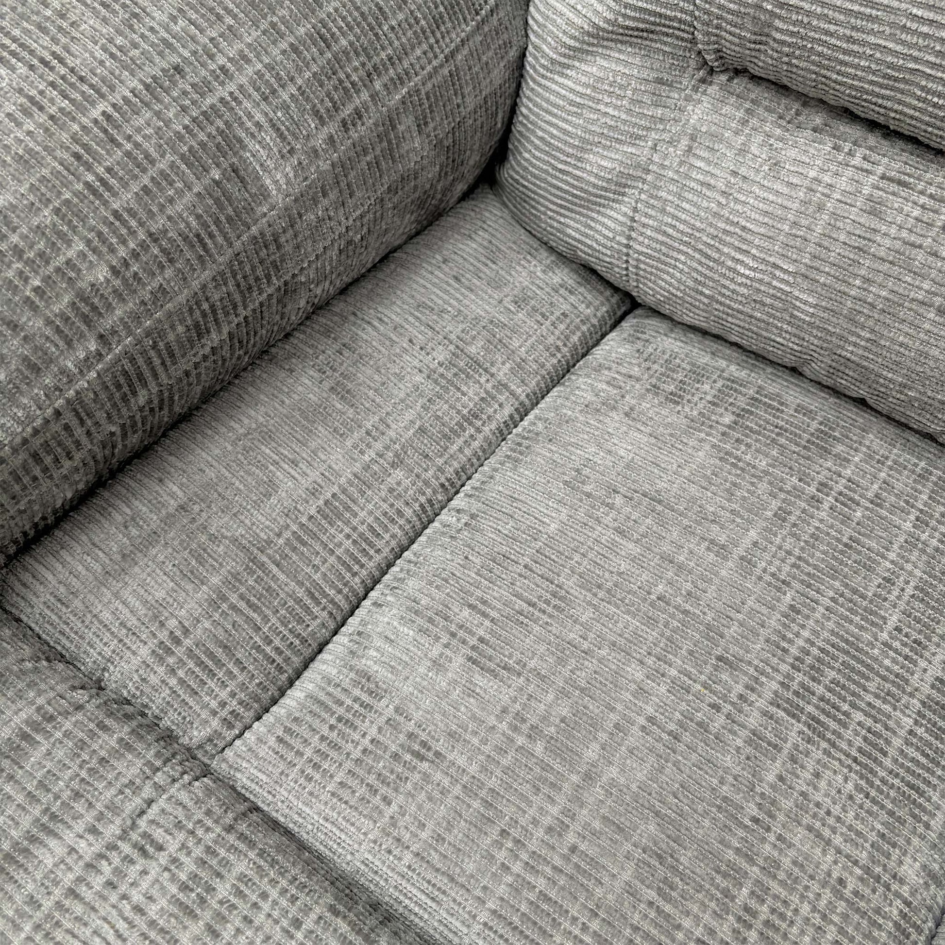 Close-up of the grey fabric texture and stitching.