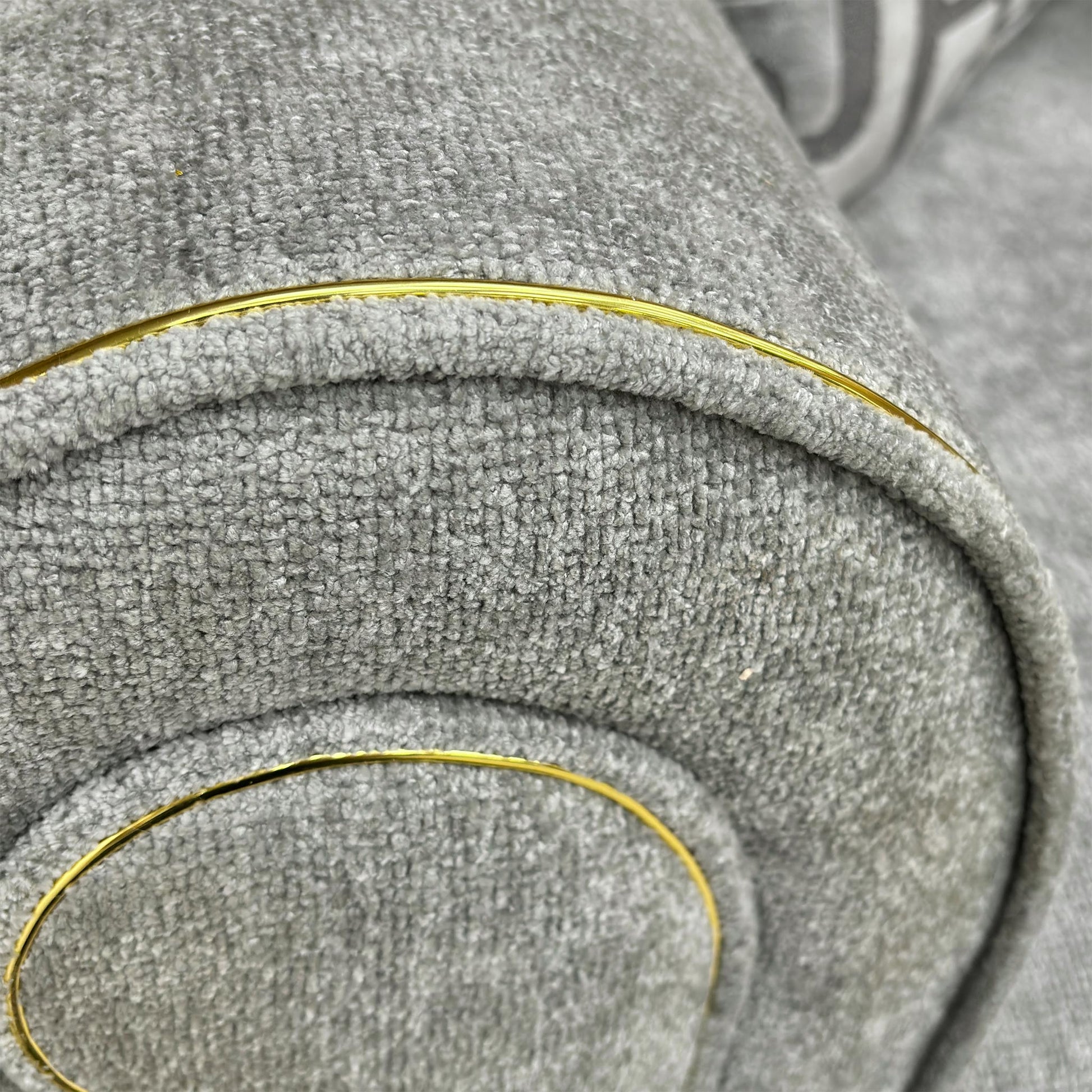 Close-up view of the matching Snuggler Chair (140 cm wide) showing its curved profile and wooden feet.