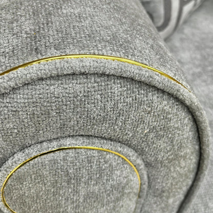 Close-up view of the matching Snuggler Chair (140 cm wide) showing its curved profile and wooden feet.