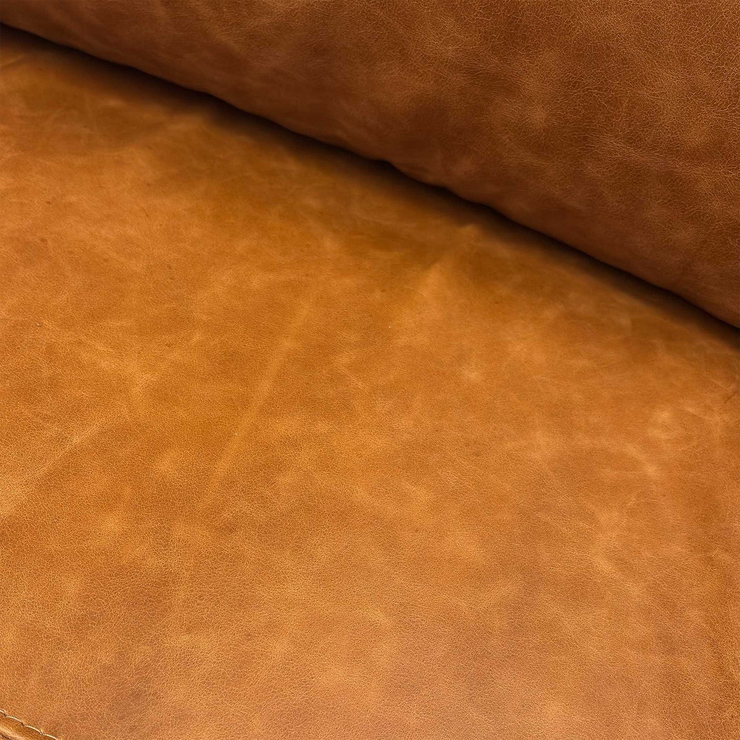 Close-up of the distressed teak brown leather texture and stitching detail.
